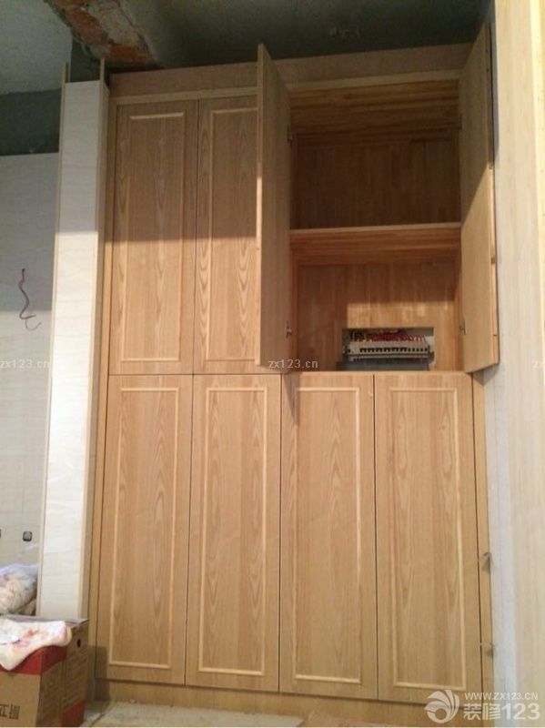 跟之前图纸设计得稍微有点出入，因为考虑到门槛比较低，撤销了门那里的吊柜，内部增加了一个保险柜。值得一提的是，木工师傅特地做了一个收纳格，这个特费手工，还加上后期的打磨。相信喷上油漆之后一定更美。做了两个柜子，一个大衣柜，一个小衣柜。亮点就是左下角的抽屉柜，可以放置一些贵重物品，我觉得我们家特漂亮的就是柜门，妈妈很有心的在每块门板上加了木条做造型。让平淡无奇的门板提升一个档次。后期加上白色油漆和门把手会更加漂亮。